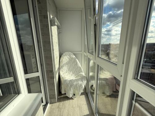 a balcony with a chair and a window at Comfort House Партизанська 25 in Bila Tserkva