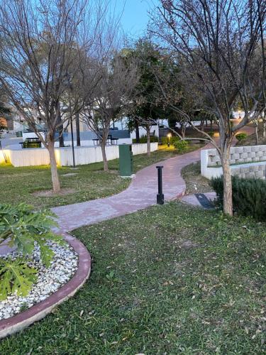 a walkway in a park with trees and grass at Cozy Room in Monterrey