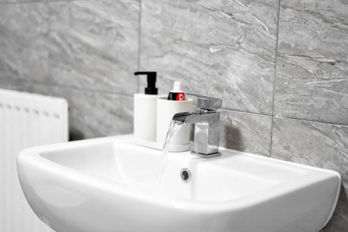 ein Waschbecken mit einem Wasserhahn darüber in der Unterkunft Luxury 2-Bedroom Home 10 Minutes from Birmingham City Centre in Birmingham