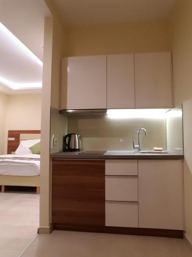 a kitchen with a sink and a bed in a room at Tündérlak Vendégház in Balatonfüred