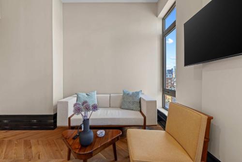 een woonkamer met een bank en een tafel bij Freeman 901 by Rove Studio with Shared Amenities in New York