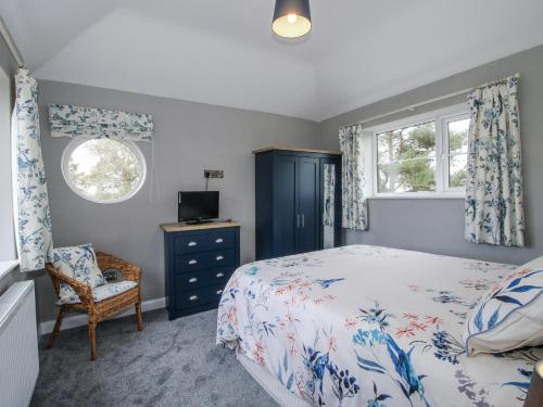 a bedroom with a bed and a chair and a window at Garden Cottage in Petton