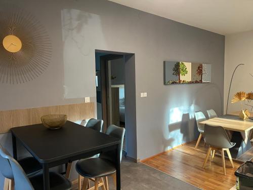 a dining room with a black table and chairs at Appartamento Carducci in Pieve di Cadore