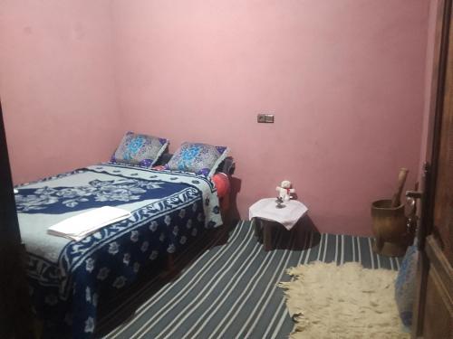 a bedroom with a bed and a small table at Bivouac beauté du désert in Mhamid