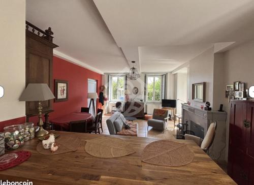 罗纳河畔的图尔农Casa mARTa : Suites, terrasses et vue panoramique的一间客厅里有一张餐桌，还有一间客厅的墙壁是红色的。