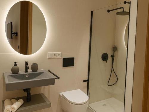 a bathroom with a sink and a toilet and a mirror at Mosquera Palace MSuites in Málaga