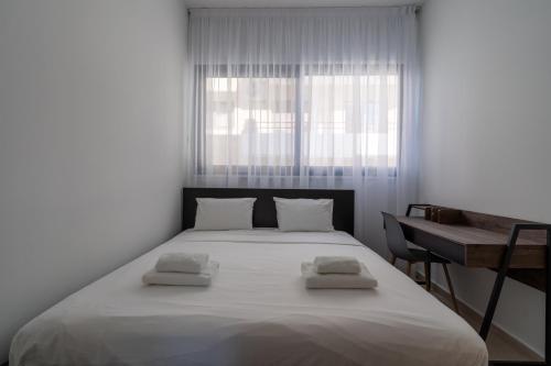 Pearl Beach Luxury Family Suite في ليماسول: غرفة نوم بها سرير أبيض كبير ومكتب