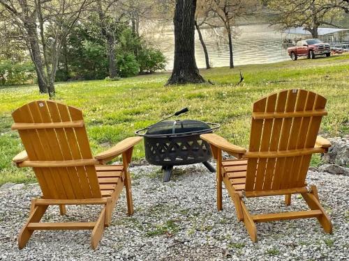 two chairs and a fire grill in a yard at Cozy Cottage - Lakeview in Reeds Spring