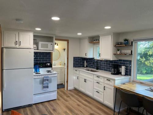 una grande cucina con elettrodomestici bianchi e un tavolo di Cozy Cottage - Lakeview a Marmaros