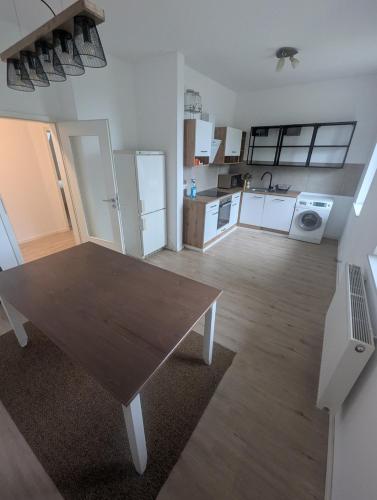een woonkamer met een houten tafel en een keuken bij Samast Apartment in Seelze