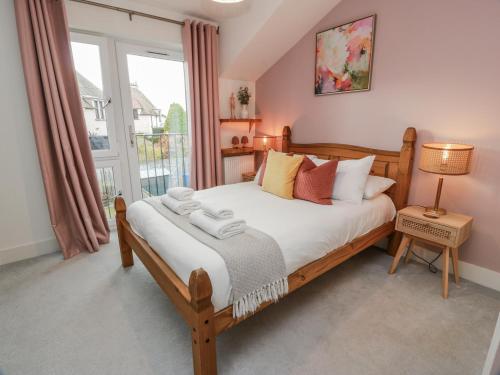 a bedroom with a large bed and a window at 14 Old Market Place in Bonnyrigg