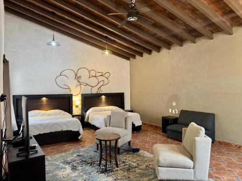 ein Hotelzimmer mit 2 Betten, einem Sofa und Stühlen in der Unterkunft Galera centro de Tepoztlan in Tepoztlán