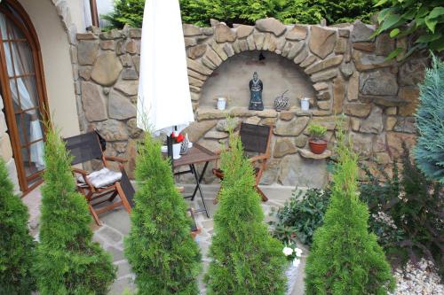 a stone wall with a table and chairs and an umbrella at Feniks Agro&Spa Adults Only in Świnoujście