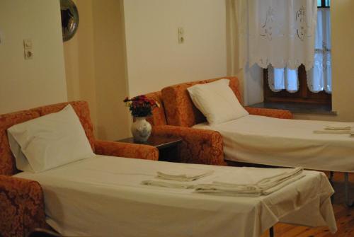 a room with two beds and two chairs and a table at Rodami in Kalentzi