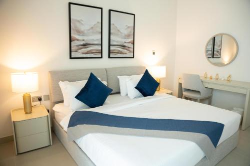 a bedroom with a large bed with blue pillows at Luxury Yas Golf Studio Next to Yas Parks in Abu Dhabi