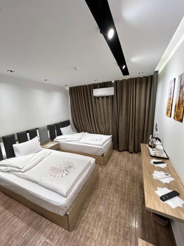 A bed or beds in a room at Grand Hotel - فندق جراند أوتيل