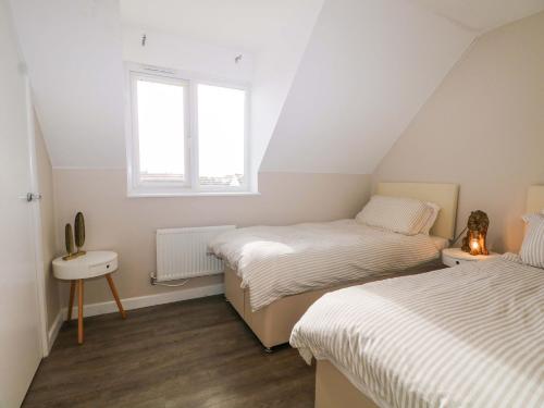 a bedroom with two beds and a window at Harbour Way in Shoreham-by-Sea