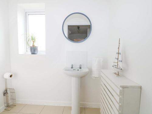 a white bathroom with a sink and a mirror at Harbour Way in Shoreham-by-Sea