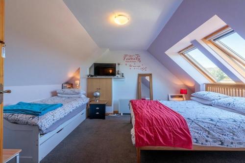 ein Schlafzimmer im Dachgeschoss mit zwei Betten und einem Fenster in der Unterkunft Burnside Cottage & Caravan Woodend in Portree