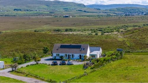 an aerial view of a house in the middle of a field at Burnside Cottage & Caravan Woodend in Portree