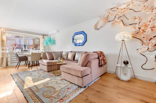 a living room with a pink couch and a table at PANORAMIC Apartment with Terrace on HARRODS in London