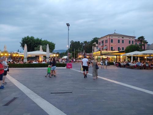 un grupo de personas caminando por una plaza de la ciudad en Eli's House in Bardolino sul Garda, en Bardolino