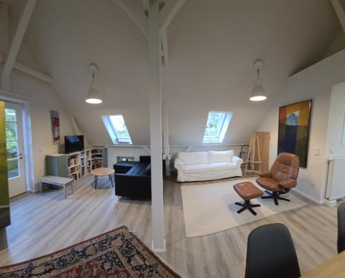 un soggiorno con un divano bianco e sedie di Auszeit im Backhuus a Teschendorf