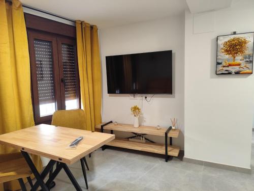 a dining room with a table and a television on a wall at Raíces de Alcalá in Alcalá del Júcar