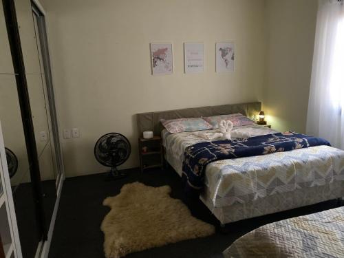 a bedroom with a bed and a rug at Apzinho do Centro in Nova Petrópolis
