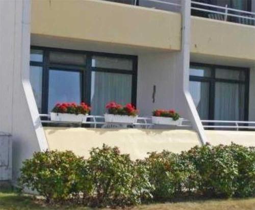 - un bâtiment avec deux fenêtres avec des pots de fleurs dans l'établissement OASE in Burgtiefe, à Burgtiefe auf Fehmarn 