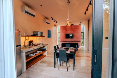 a kitchen and dining room with a table and chairs at Casa Oneiro Hotel Boutique & Suites in Mérida