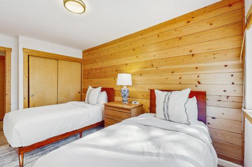 twee bedden in een kamer met houten wanden bij Alpine Retreat in Truckee