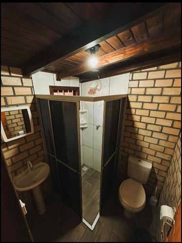 a small bathroom with a toilet and a sink at Pousada Toca da Coruja Chales pequeno in Balneário Gaivotas