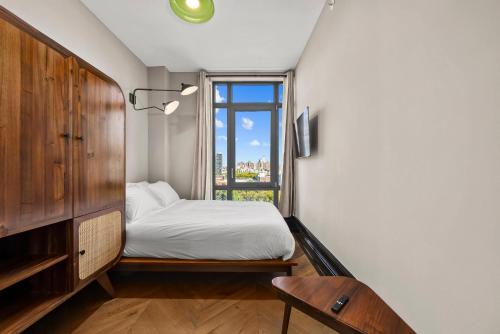 a bedroom with a bed and a window at Freeman 903 by Rove 1BR Condo with Shared Amenities in New York