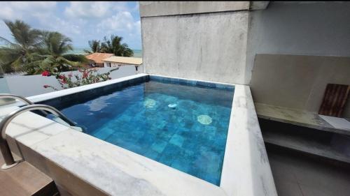 een zwembad bovenop een gebouw bij rooftop Bellamar in Pôrto de Pedras