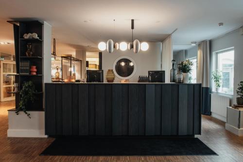 a lobby with a black counter in a room at Home Hotel Fregatten in Varberg