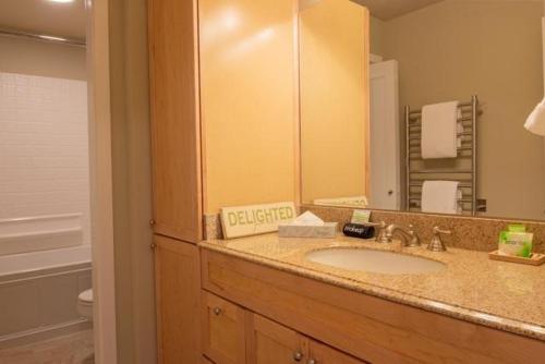 un bagno con un lavandino e un grande specchio di Atelier Condo 1035 a Sun Valley