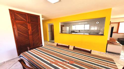 a yellow wall in a room with a bed at Casa em Ubatuba a 350m da Praia das Toninhas - Casa Praia in Ubatuba