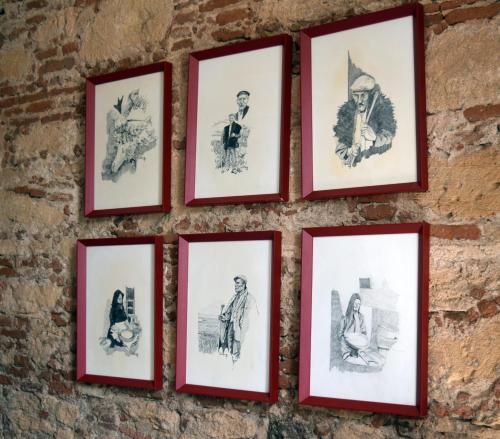 a group of framed photographs on a brick wall at Eleonora Room & Breakfast in Oristano