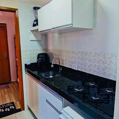 a kitchen with a sink and a stove at Apartamento Paraíso Refúgio - Manoah Beach Flats in Maragogi