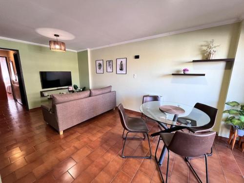 ein Wohnzimmer mit einer Couch und einem Tisch und Stühlen in der Unterkunft Departamento 1 dormitorio a metros de Patio Olmos in Cordoba