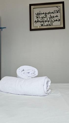 stos ręczników siedzących na łóżku w obiekcie Dar Elyssa - Free Breakfast - Résidence Oasis Tozeur w mieście Tauzar