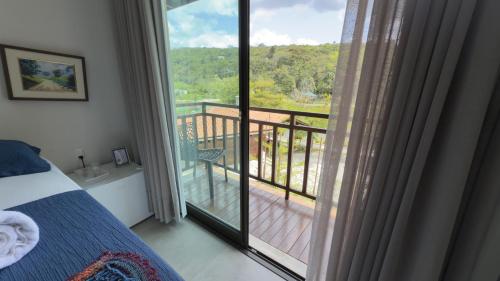 a bedroom with a bed and a view of a balcony at Pousada do Lago in Guaramiranga