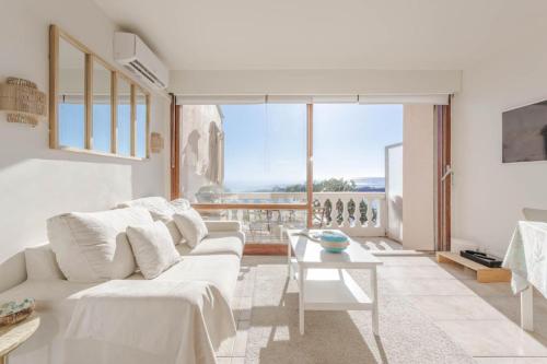 a living room with a white couch and a table at Petit Paradis vue Mer- Plage et calanques a 3 mn in Saint-Raphaël