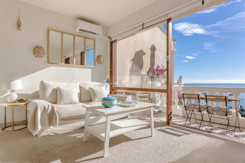 a living room with a white couch and a table at Petit Paradis vue Mer- Plage et calanques a 3 mn in Saint-Raphaël
