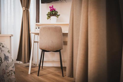 a chair sitting at a desk in a room with curtains at Casamè Apartment Sulmona - a due passi da centro, free bike park in Sulmona