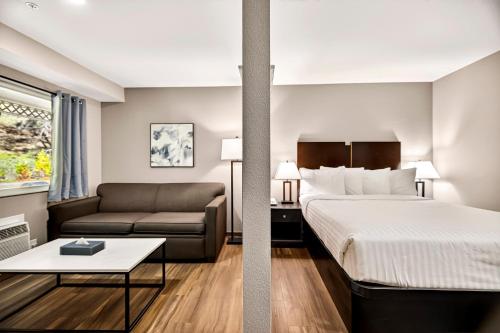 ネバダシティにあるNorthern Queen Innのベッドとソファのあるホテルの部屋