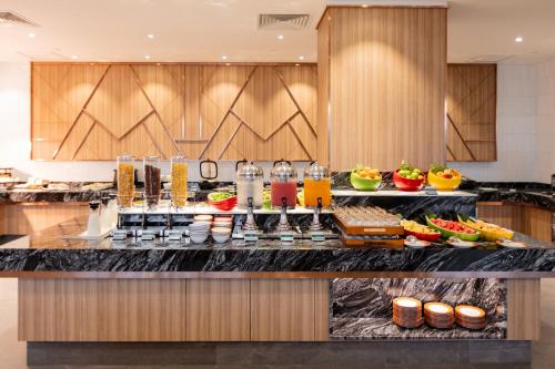 a breakfast buffet in a hotel kitchen with food at Holiday Inn Sepang - Airport in Sepang
