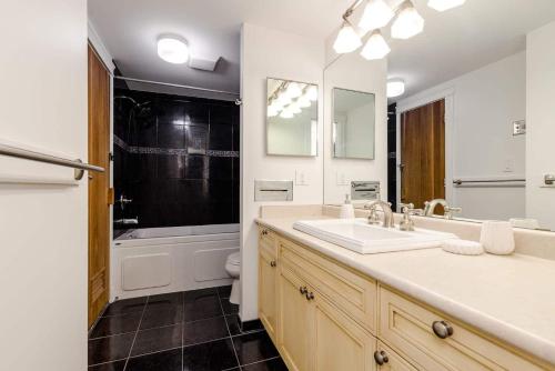 um banheiro com uma pia, uma banheira e um vaso sanitário em Whistler Village Retreat, Private Hot Tub & Sauna em Whistler