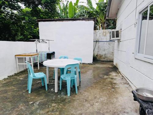 a table and two chairs and a white table and chairs at Staycation in Naic Cavite near Torres Farm & Beach in Naic